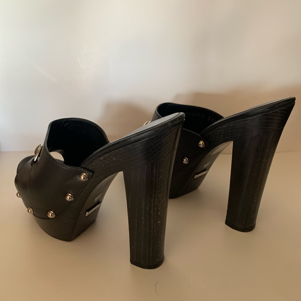 New/unused Gucci black leather horse-bit high heel mules.